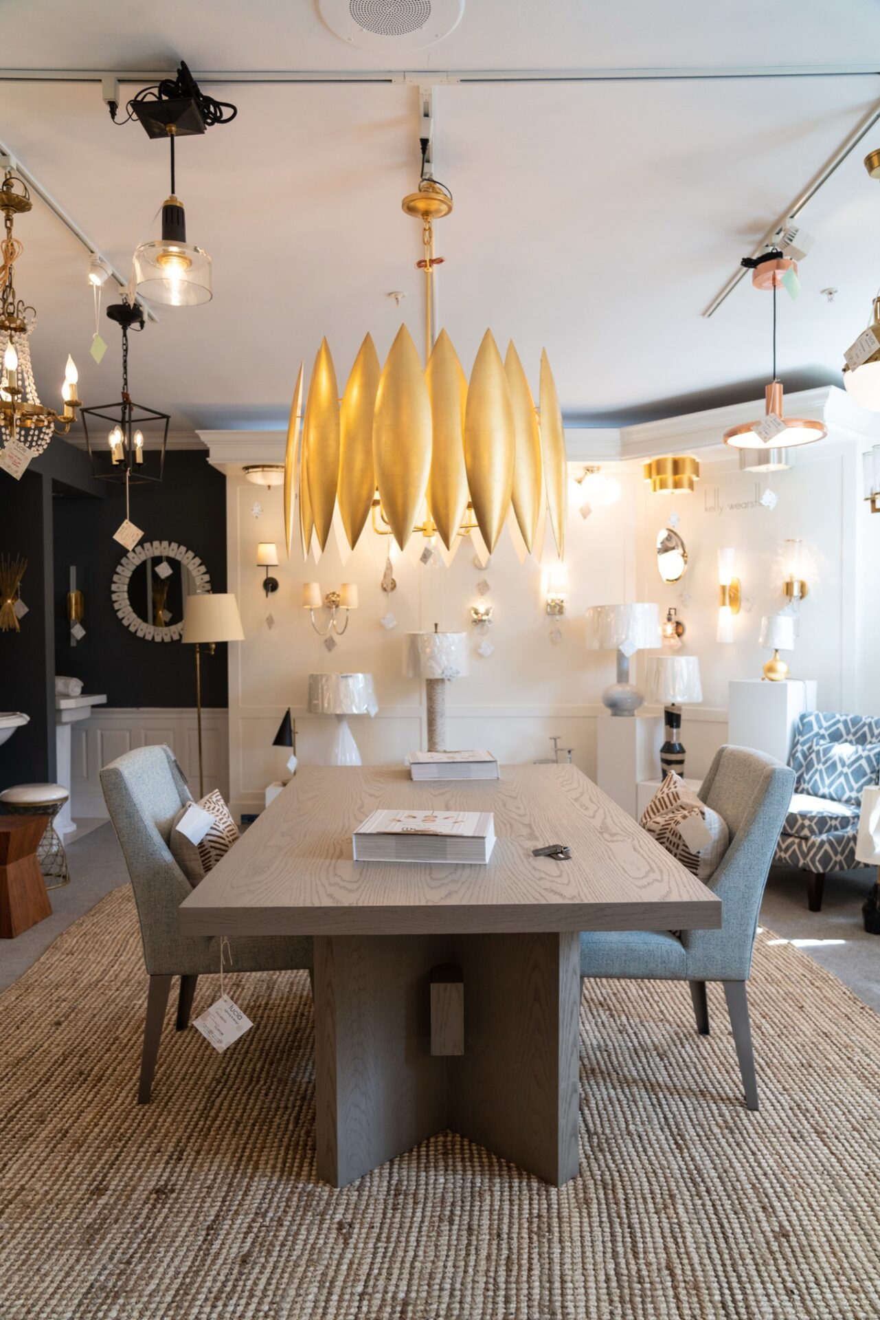 Gold leaf chandelier over a dining table in the Lucía Lighting and Design showroom