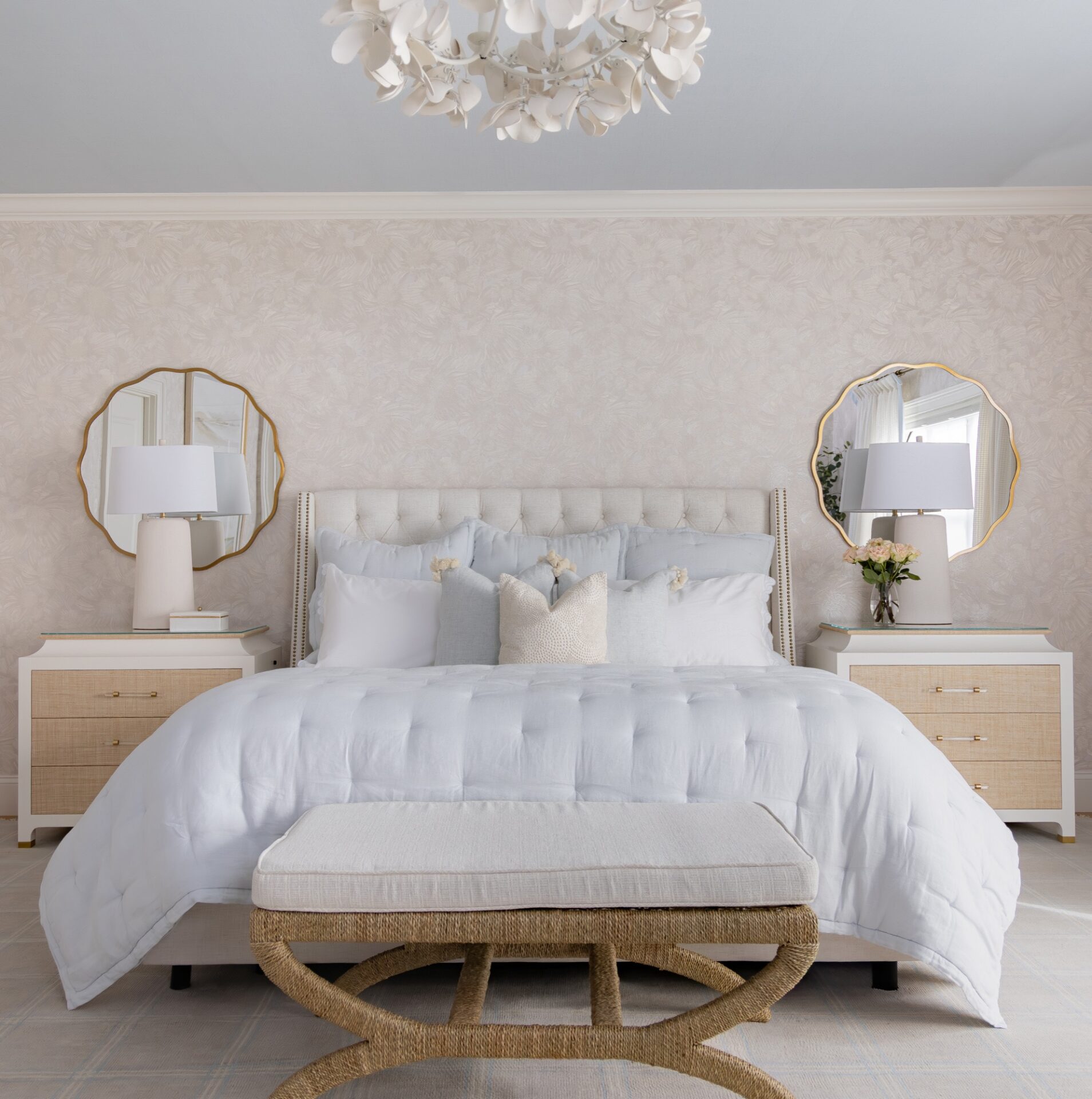 Serene bedroom with a tufted headboard, scalloped mirrors, and a woven bench by Main Street Home