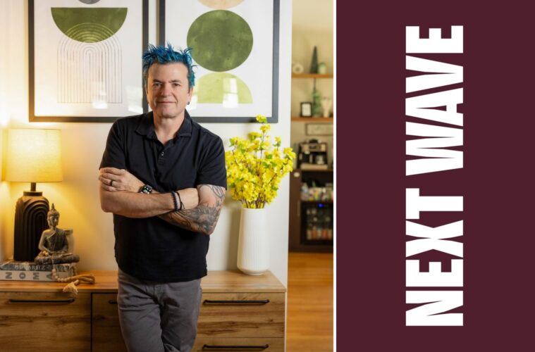 Jason Santos stands with his arms crossed in a restaurant beside vertical Next Wave lettering on maroon.