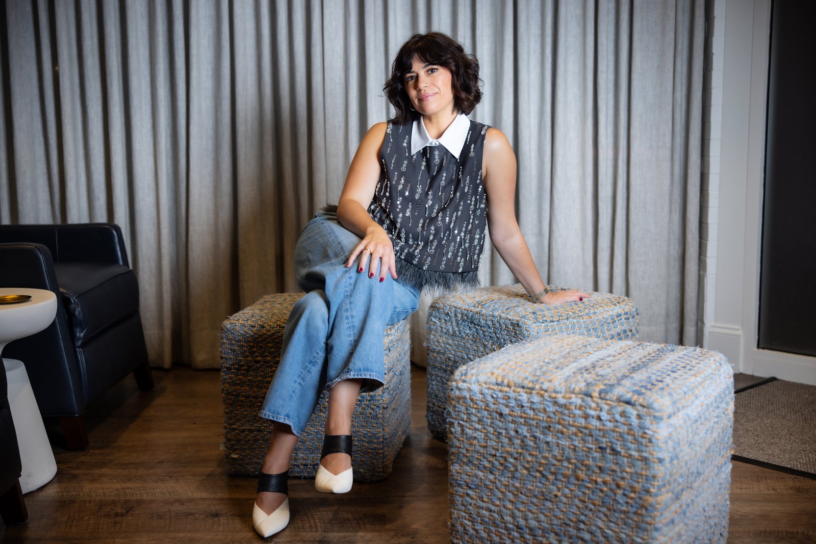 Jordan Becker sits on a woven chair at INTERLOCKS in Newburyport.