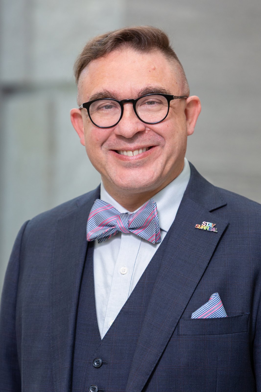 Kurt Steinberg smiles while wearing glasses, a bow tie, and a dark suit.