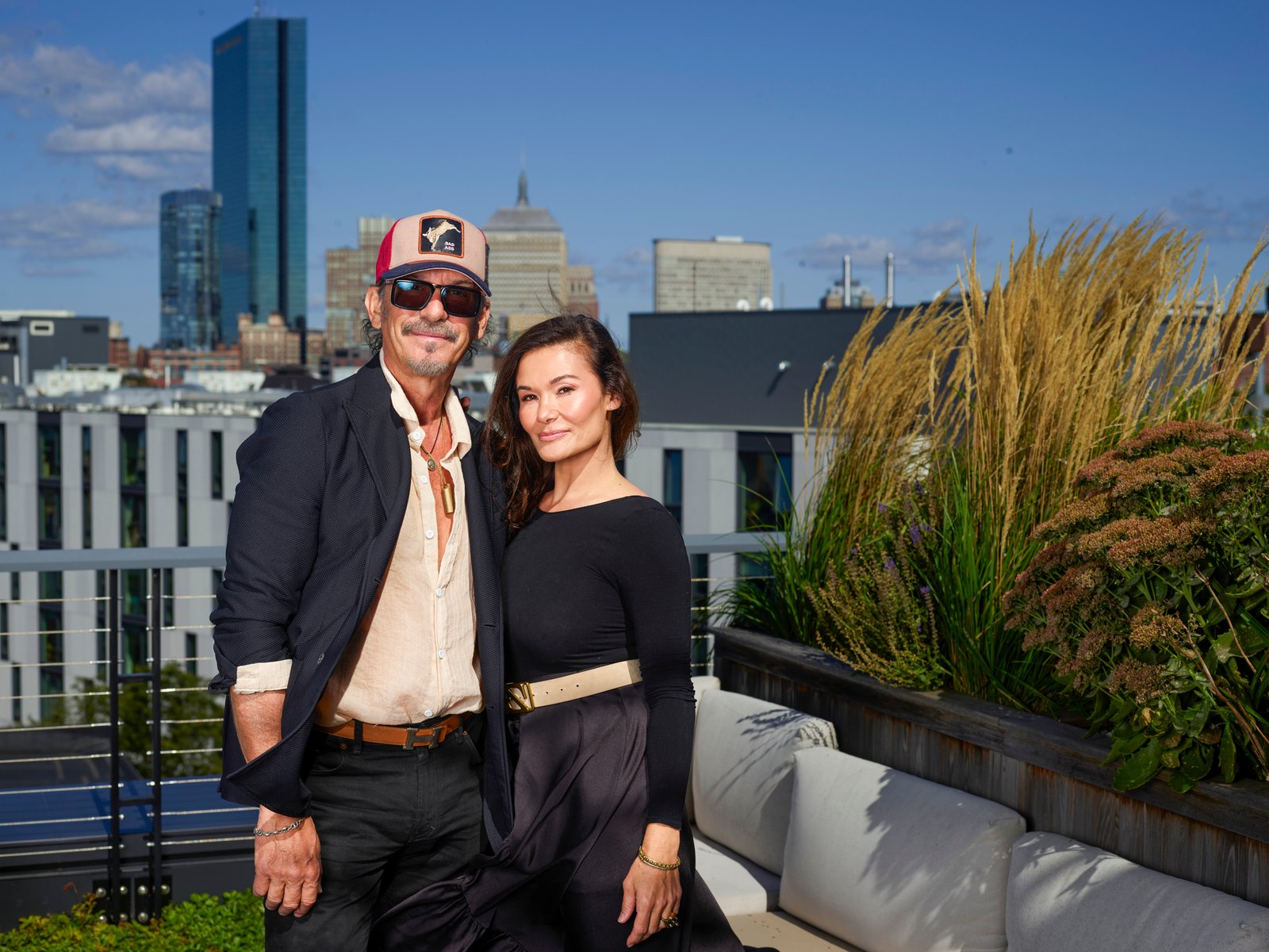 Marc Harris and Maria Lekkakos stand on a rooftop with the Boston skyline behind them.