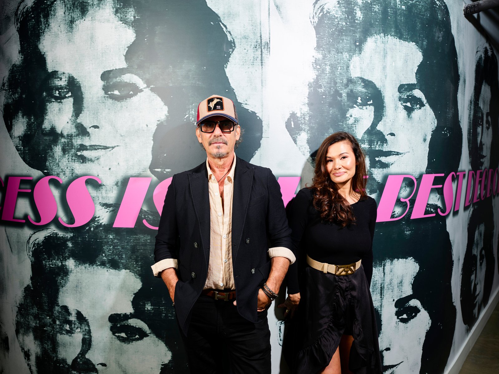 Marc Harris and Maria Lekkakos stand in front of a black-and-white mural.